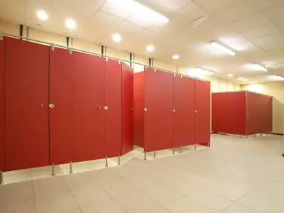 Cabinas sanitarias de compacto fenólico rojo en un aseo público
