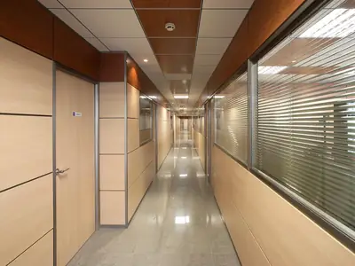 Pasillo de oficinas con mampara de doble panel en madera y cristal con persianas