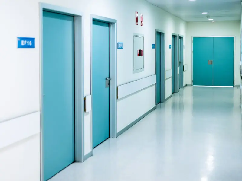 Pasillo de hospital con puertas técnicas HPL de color turquesa