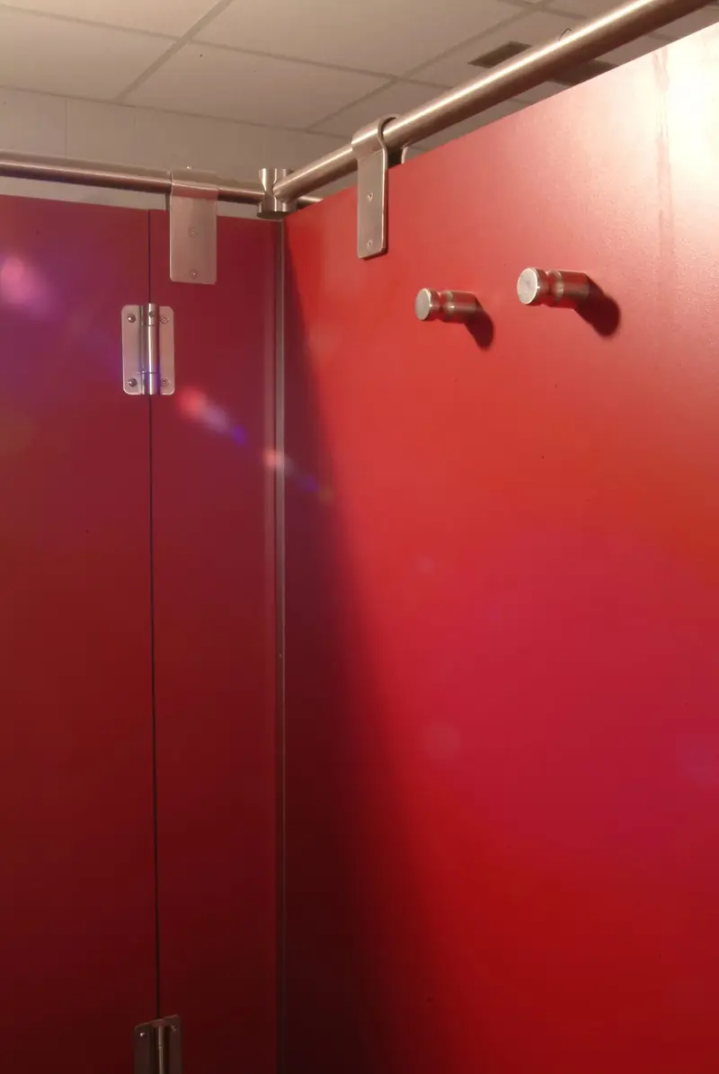 Detalle de las pinzas y la unión de tubo de acero inoxidable en la esquina de una cabina roja