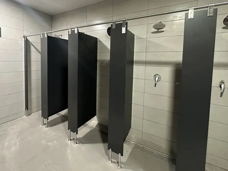 Duchas de un vestuario separadas con paneles fenólicos en antracita, abiertas en T