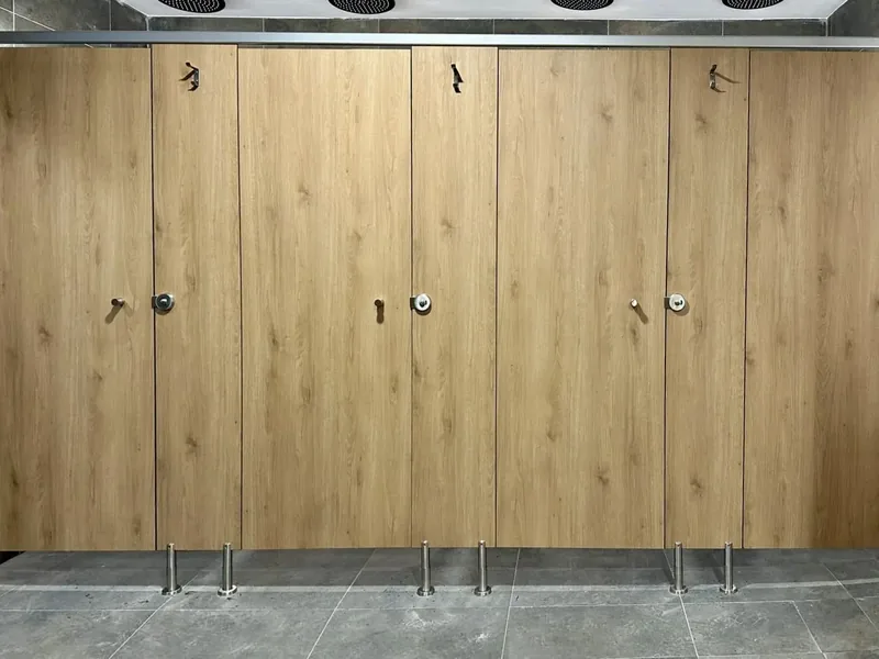 Cabinas de ducha en acabado roble, de frente, con perfil de coronación, colgador en cada puerta y pies regulables