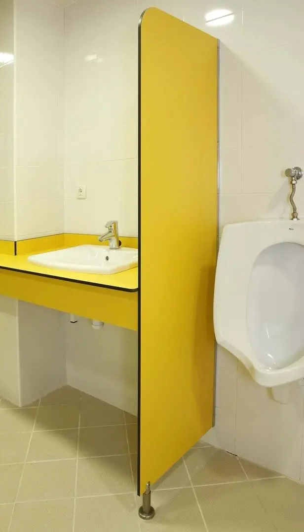 Quitavistas de compacto fenólico amarillo en la entrada de un aseo