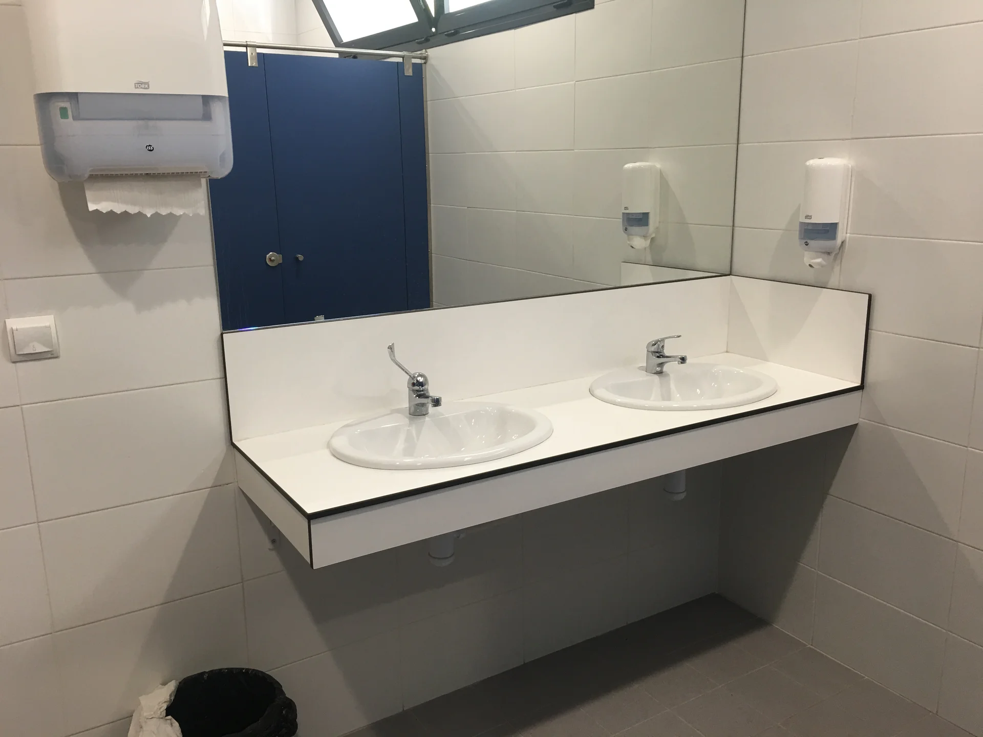 Encimera fenólica blanca con lavabo integrado en baño de diseño compacto - Bellum Logistics