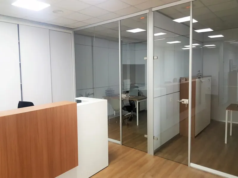Puerta de cristal templado junto a la recepción de una oficina
