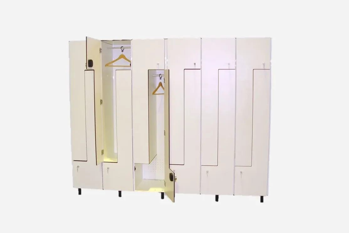 Taquillas blancas con puertas en L abiertas y perchas colgadas en la barra del hueco alto