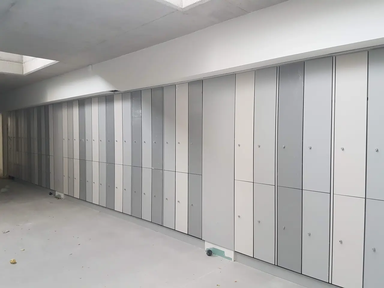 Hilera larga de taquillas fenólicas en grises y blanco recién montadas