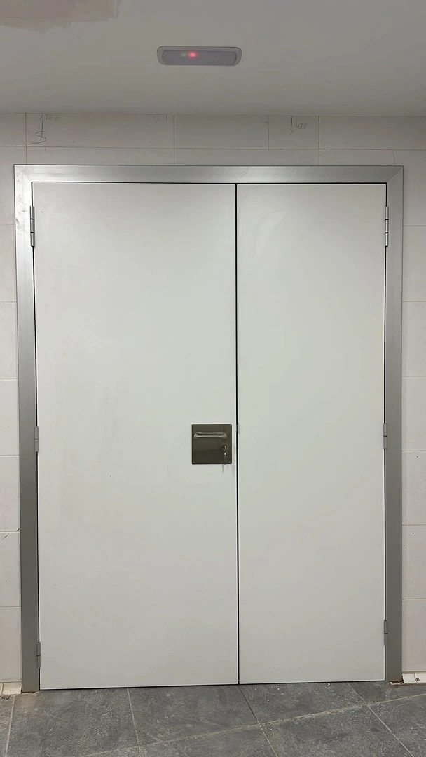 Puerta técnica acústica elaborada con compacto fenólico (HPL) de color blanco con marco telescópico de aluminio